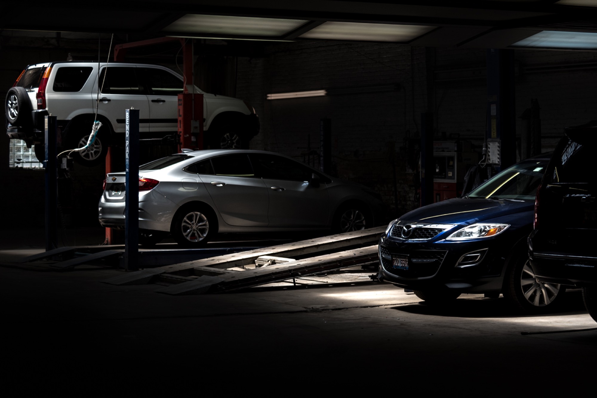 Vehicles on lifts inside the Jersey Automotive repair bay
