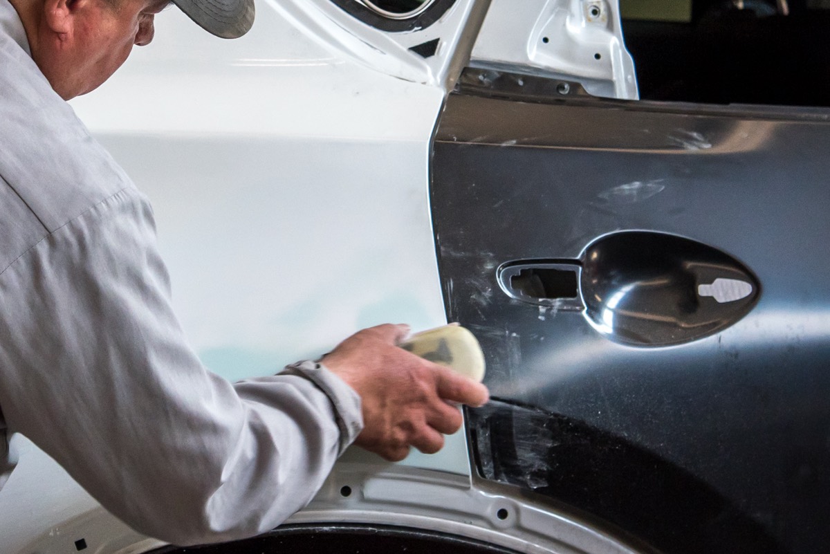 Technician repairing a damaged door panel