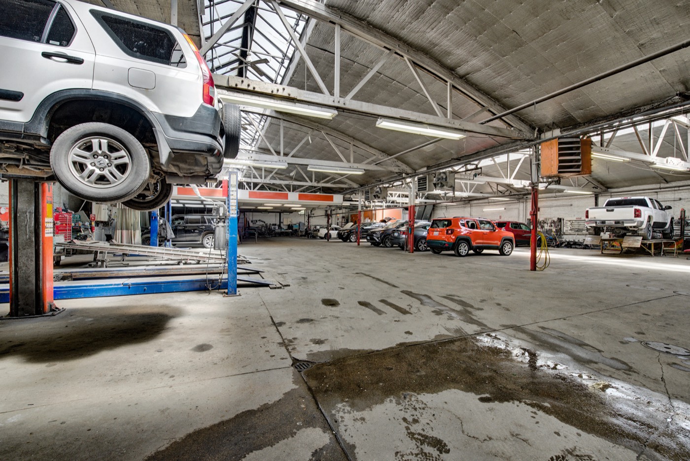 Inside the shop with a vehicle raised on a lift